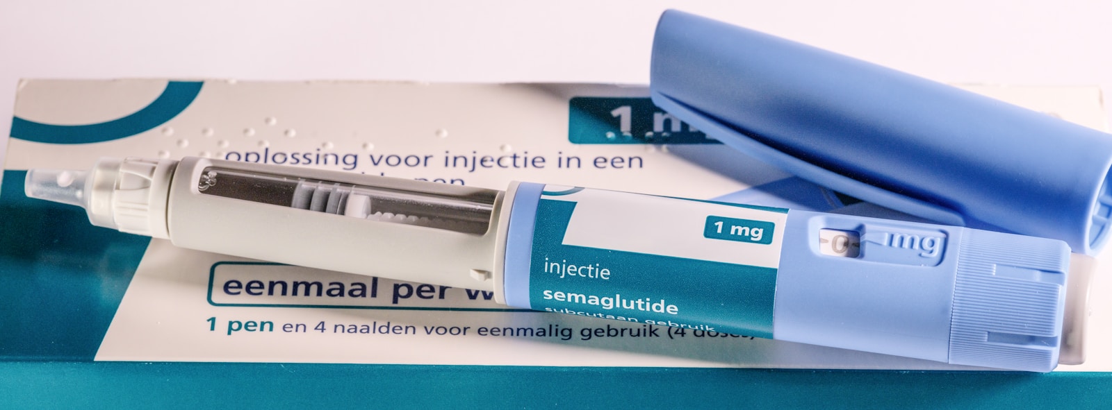 Close-up of a GLP-1 injection pen and its packaging on a clean, neutral surface